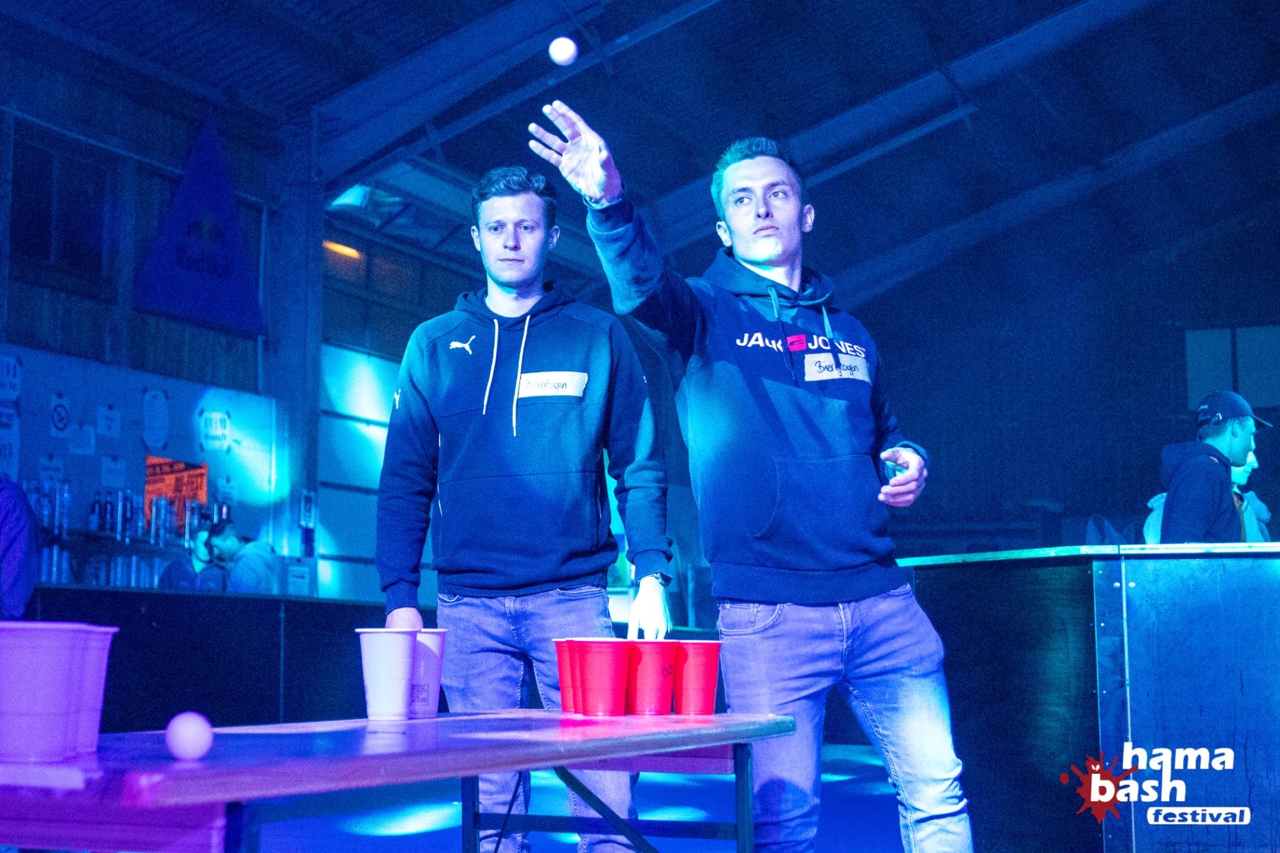 Zwei Gäste im blauen Bühnenlicht bei einer Veranstaltung