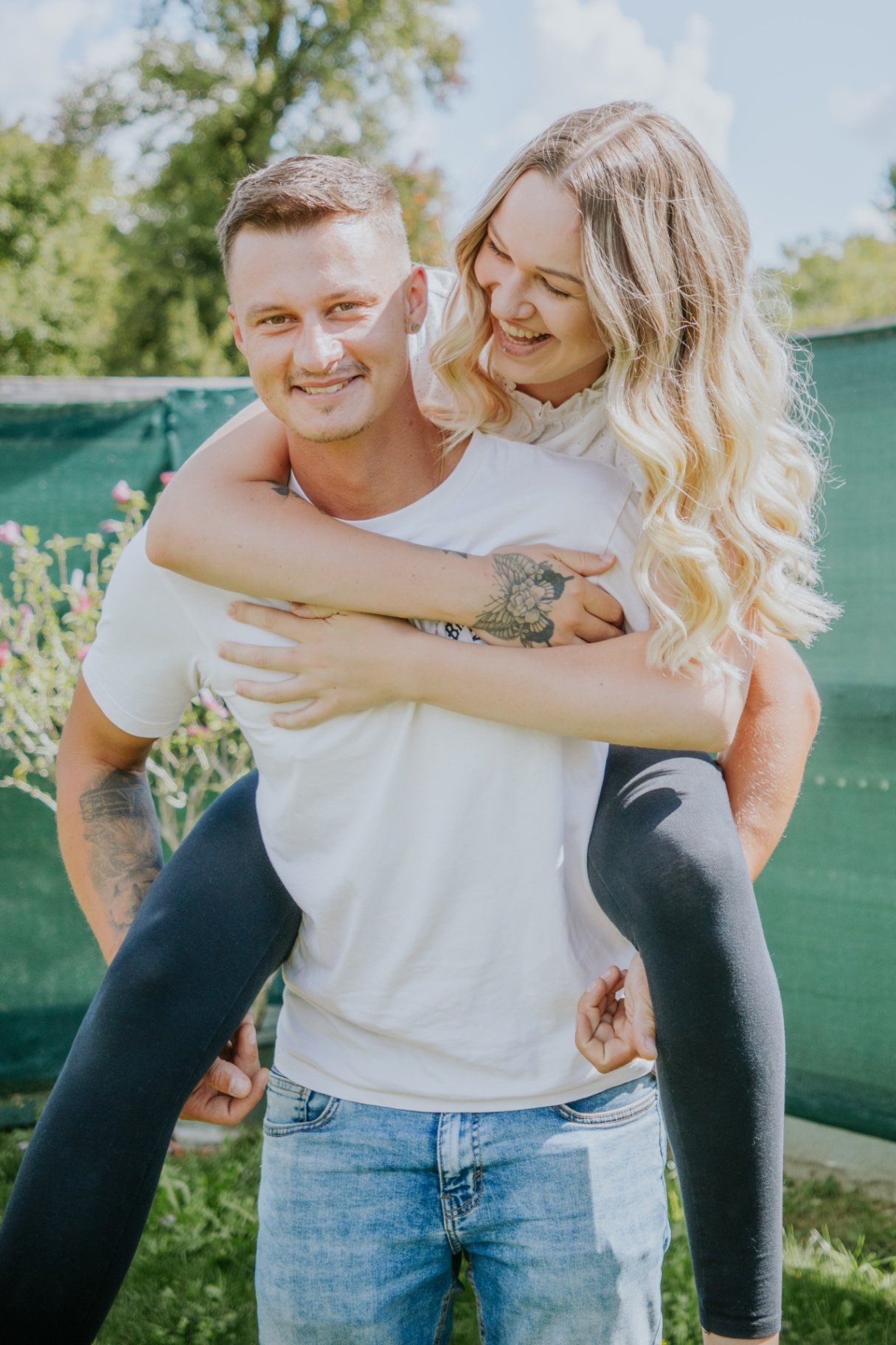 Lachendes Paar bei einem Fotoshooting im Grünen